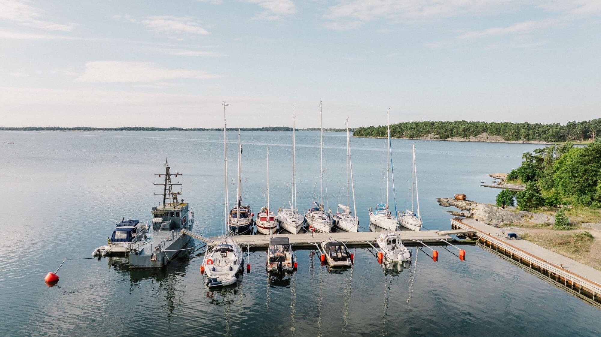 Flygfoto över gästhamnsbrygga med segelbåtar i skärgården